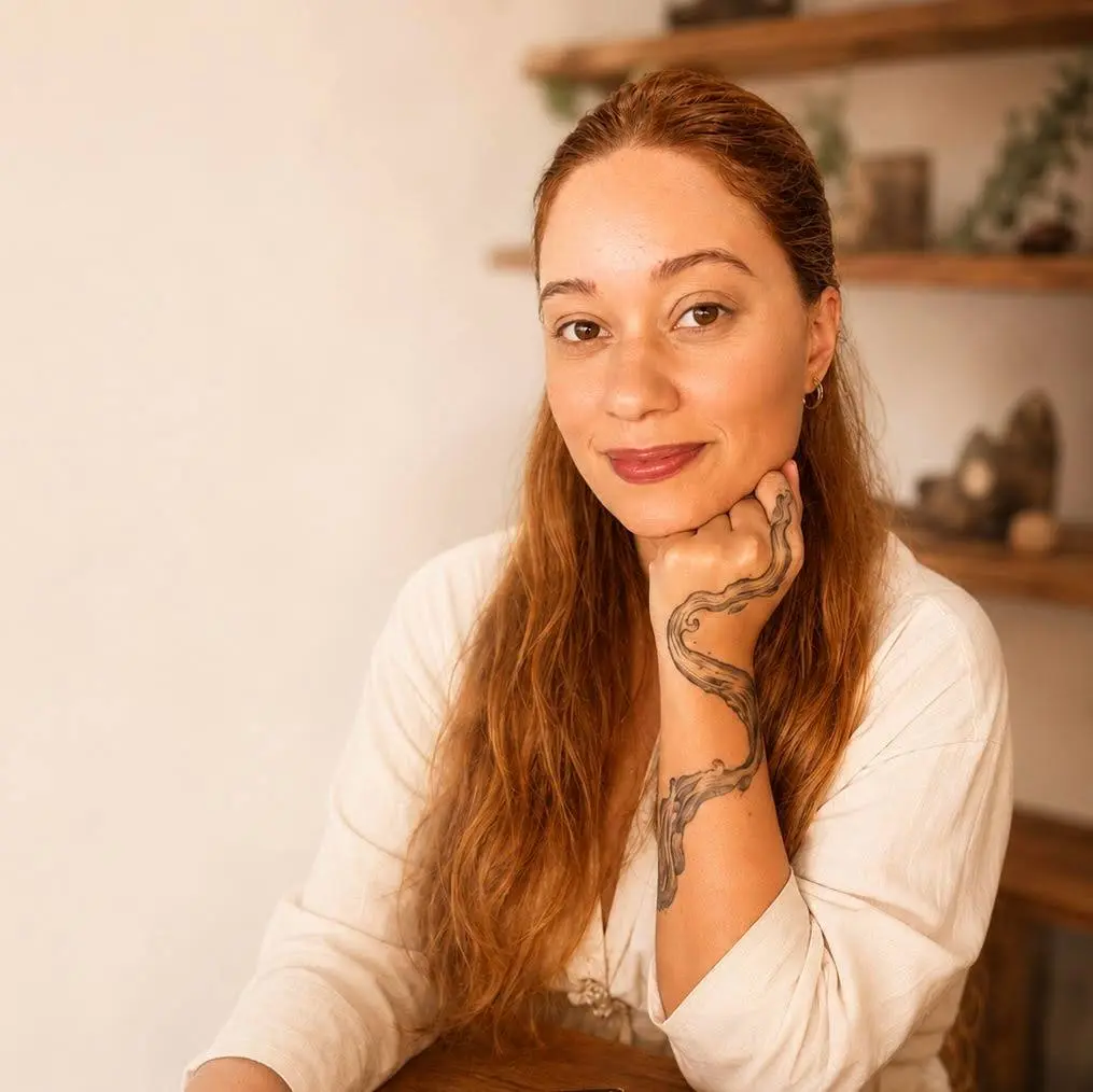 Retrato de Aline Antunes, ruiva, apoiando o queixo na mão